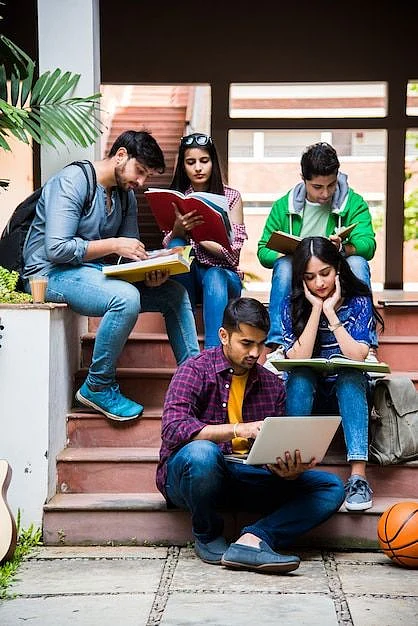 Premium Photo Young Asian Indian college students reading books studying on laptop preparing for exam or working on group project while sitting on grass staircase or steps of college campus