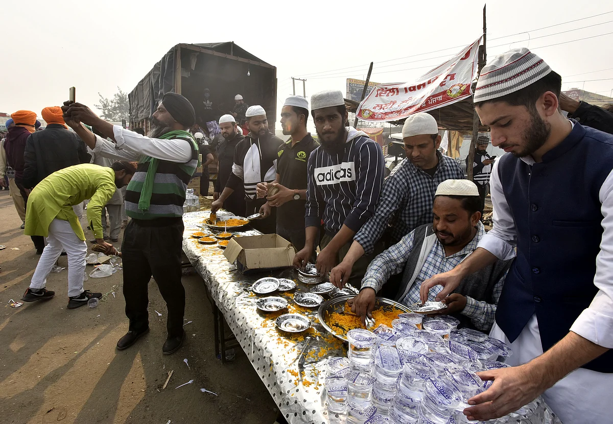 Muslim persons distribute eating food Langar to farmers during their 'Delhi Chalo' protest march against the Centre's new farm laws, at Singhu border / Getty Images