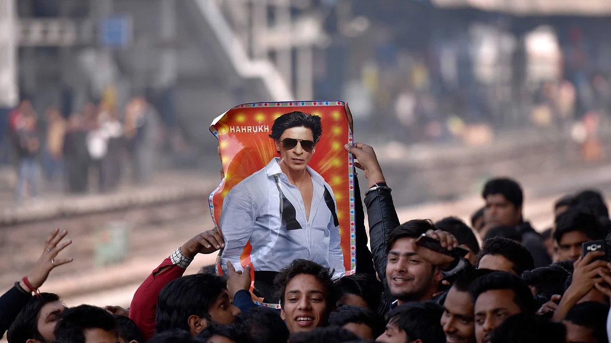 <div class="paragraphs"><p>شاہ خان کی تصویر اٹھائے ہونے ان کے مداح / Getty Images</p></div>