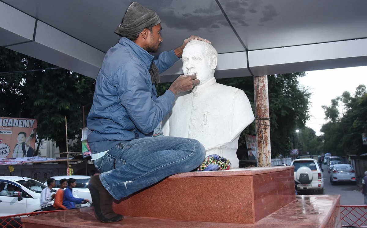 प्रियंका गांधी के दौरे से पहले लखनऊ में पूर्व प्रधानमंत्री राजीव गांधी की प्रतिमा को संवारता कार्यकर्ता