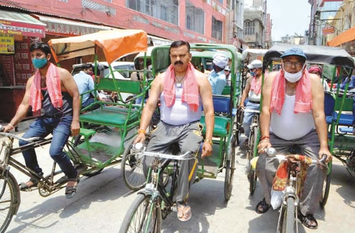 व्यापारियों ने रिक्शा चलाकर किया विरोध