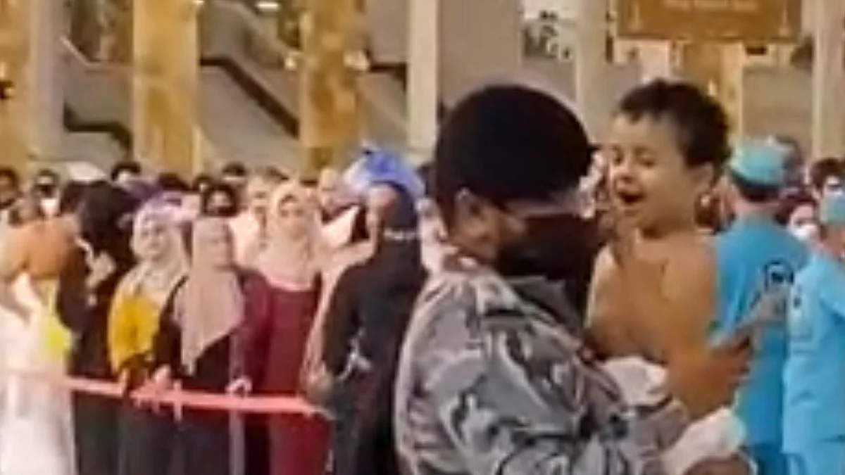 رجل أمن يحمل طفلاً فقد ذويه بالحرم