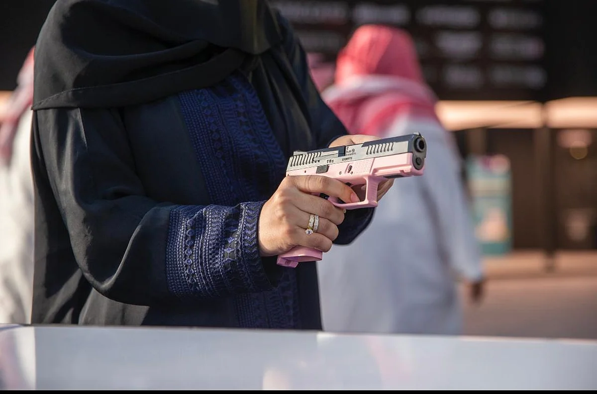 امرأة تتفقد الأسلحة خلال زيارتها لمعرض الصقور والصيد السعودي