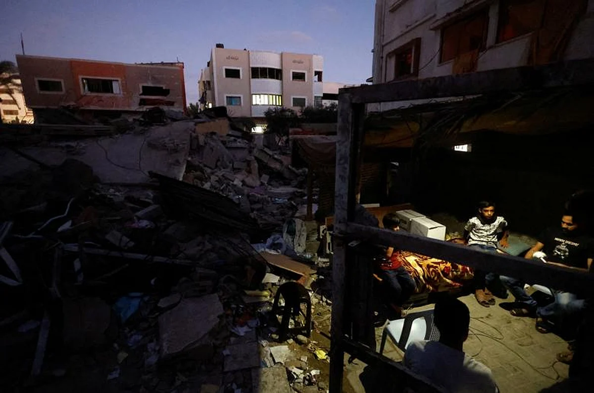 فلسطينيون يجلسون على أنقاض منازلهم