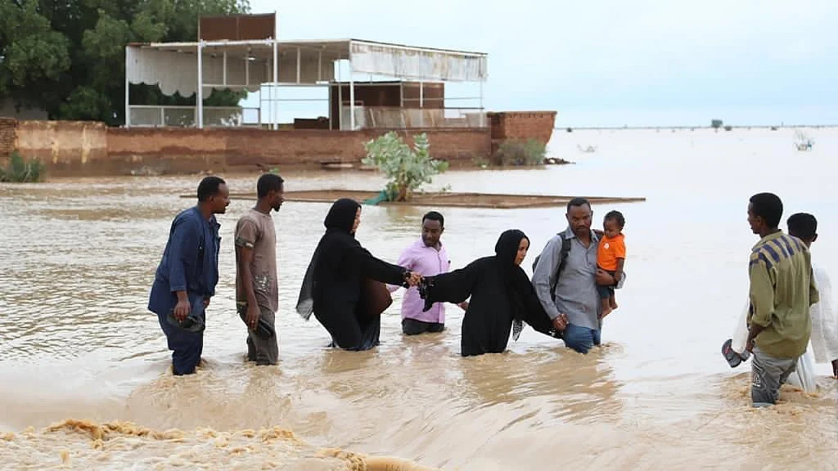 أسرة سودانية تحاول عبور مياه السيول