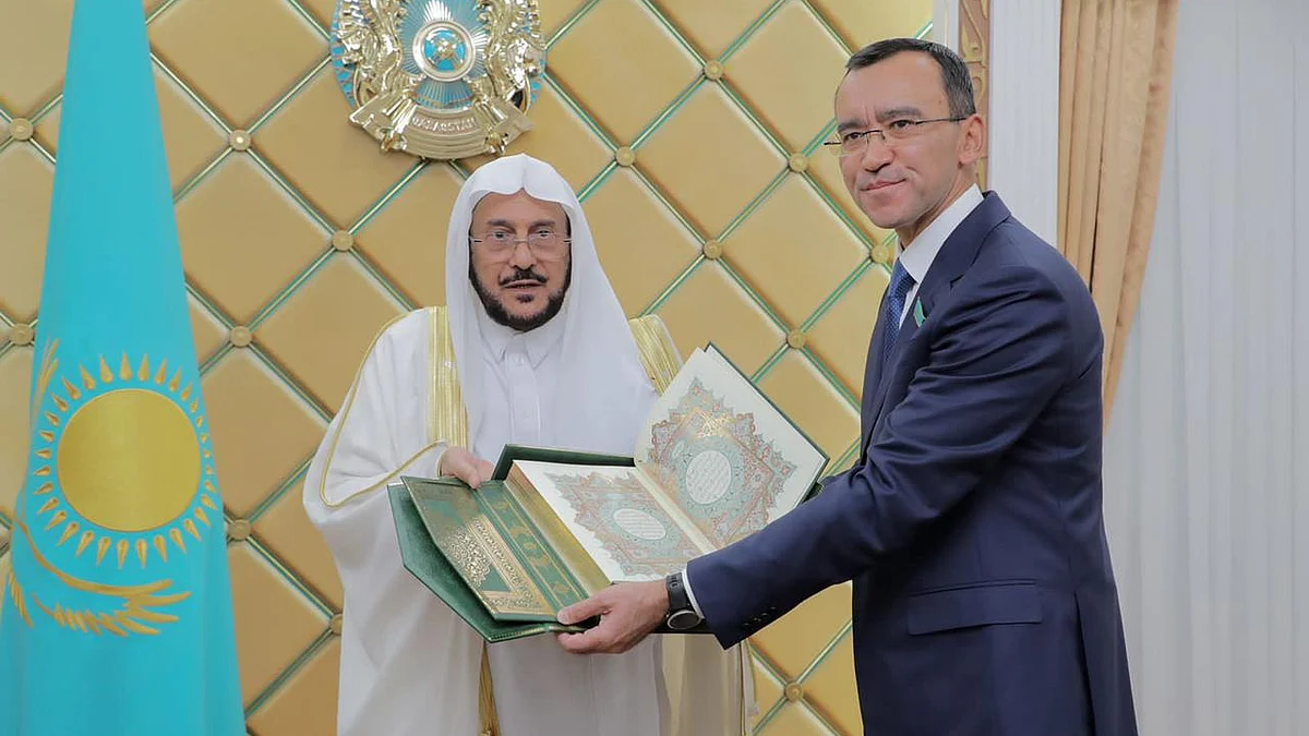 عبداللطيف آل الشيخ وماولين أشيمبايف يحملان المصحف الشريف