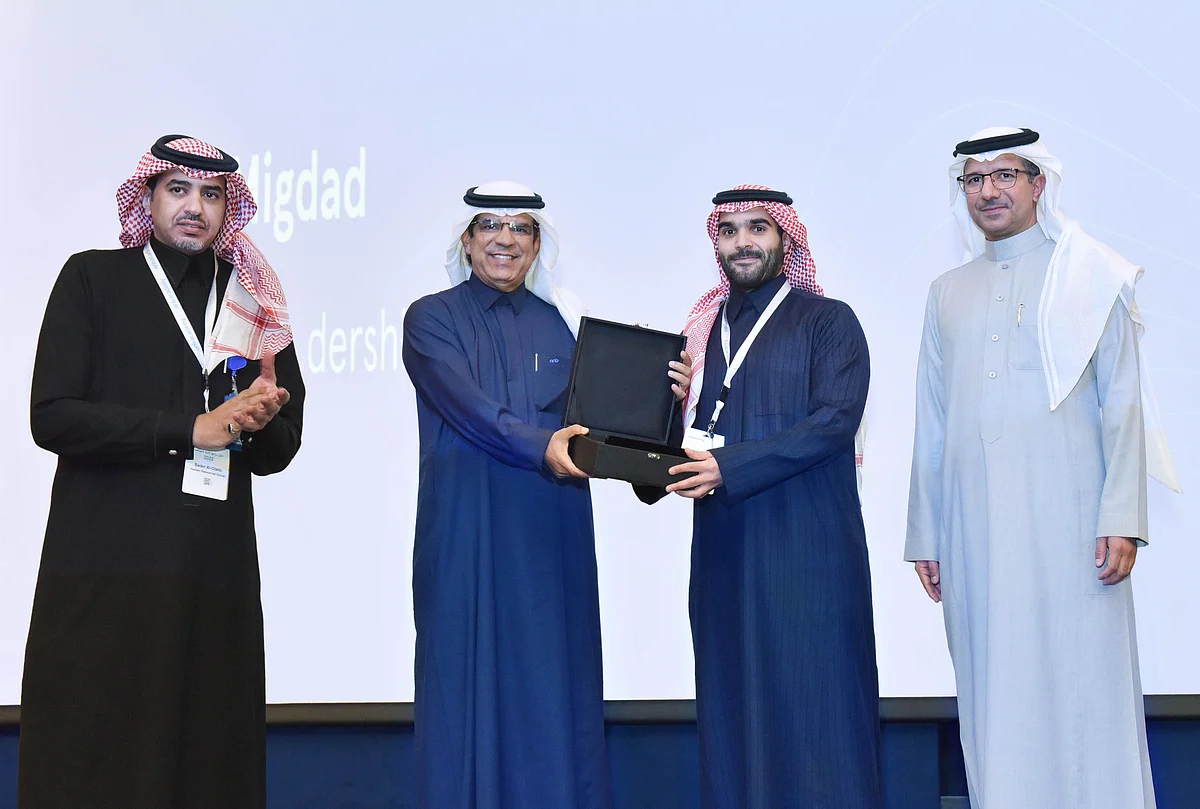 الرشيد أثناء تكريمه أحد المتدربين المميزين بحضور معالي راعي الحفل (يمين الصورة)
