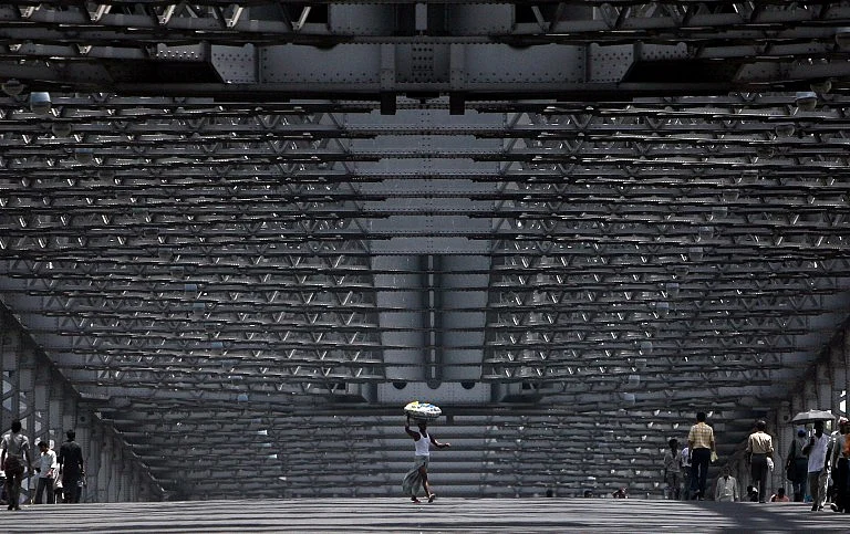 A porter crosses the deserted Howrah bridge during an earlier Bandh. (Photo: AFP PHOTO/Deshakalyan CHOWDHURY)