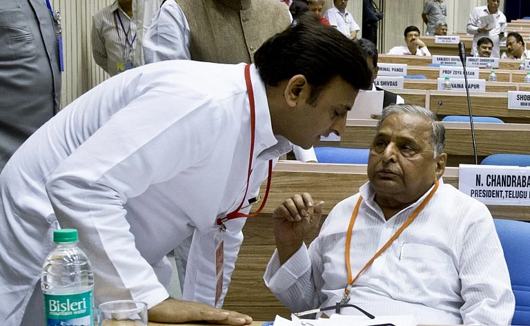 Uttar Pradesh Chief Minister Akhilesh Yadav (L) listens to his father and President of Samajwadi Party, Mulayam Singh Yadav. (Credits: AFP Photo/PRAKASH SINGH)