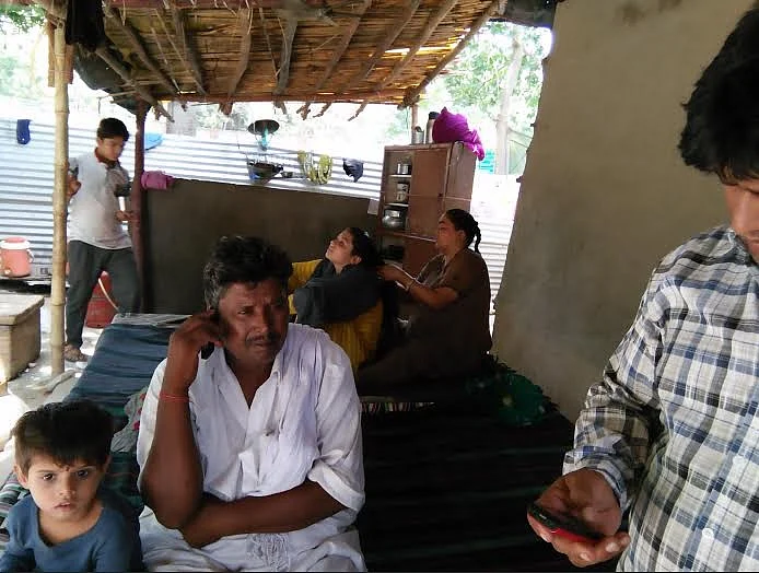This is Ram Chander; at the far end on the bed, his wife braids their daughter’s hair.