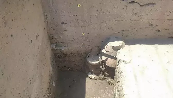 A stack of pots and a small drainage(?) pipe.