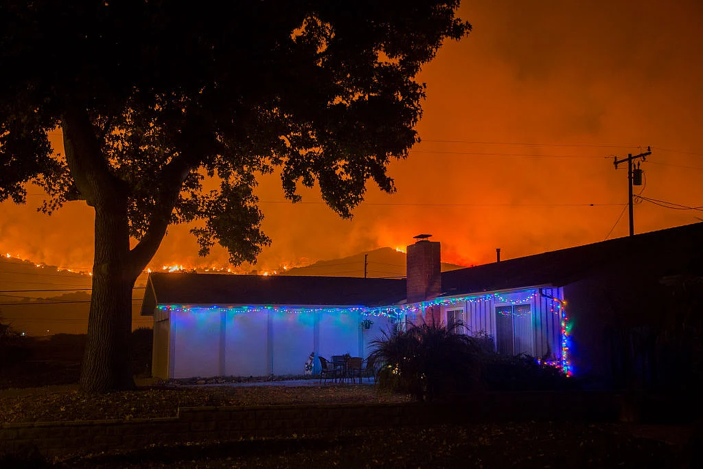 Christmas decorations illuminate a house as the growing Thomas Fire advances toward Santa Barbara County seaside communities in Carpinteria, California. (David McNew/Getty Images) 