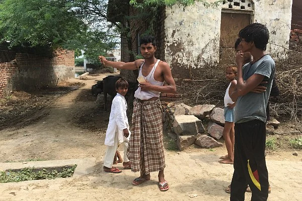 Mohammad Arif points to a pond where he does fish farming. (Swarajya)