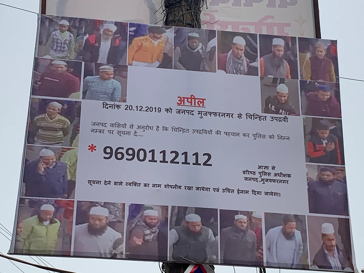A billboard at Shiv Chowk with photos of rioters