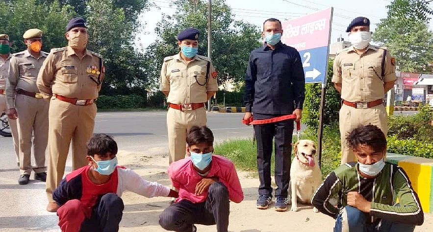 The three men arrested for the murder with cops and the tracker dog, Leena.
