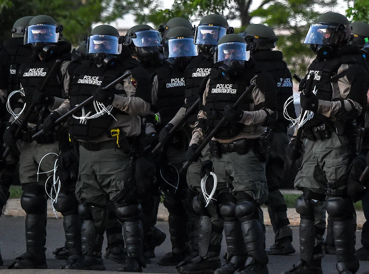 Police hold batons as they stand guard near the 5th police precinct during a demonstration to call for justice for George Floyd in Minneapolis, Minnesota