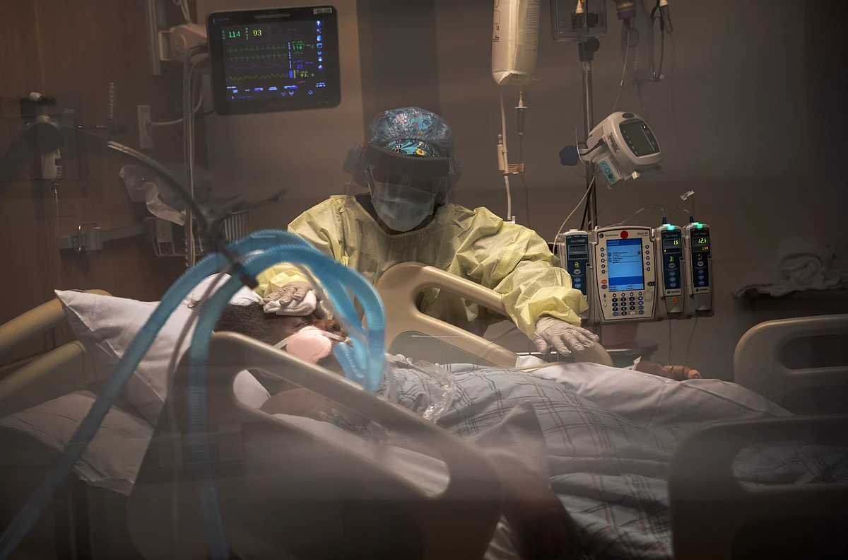 A nurse cleans a patient with COVID-19