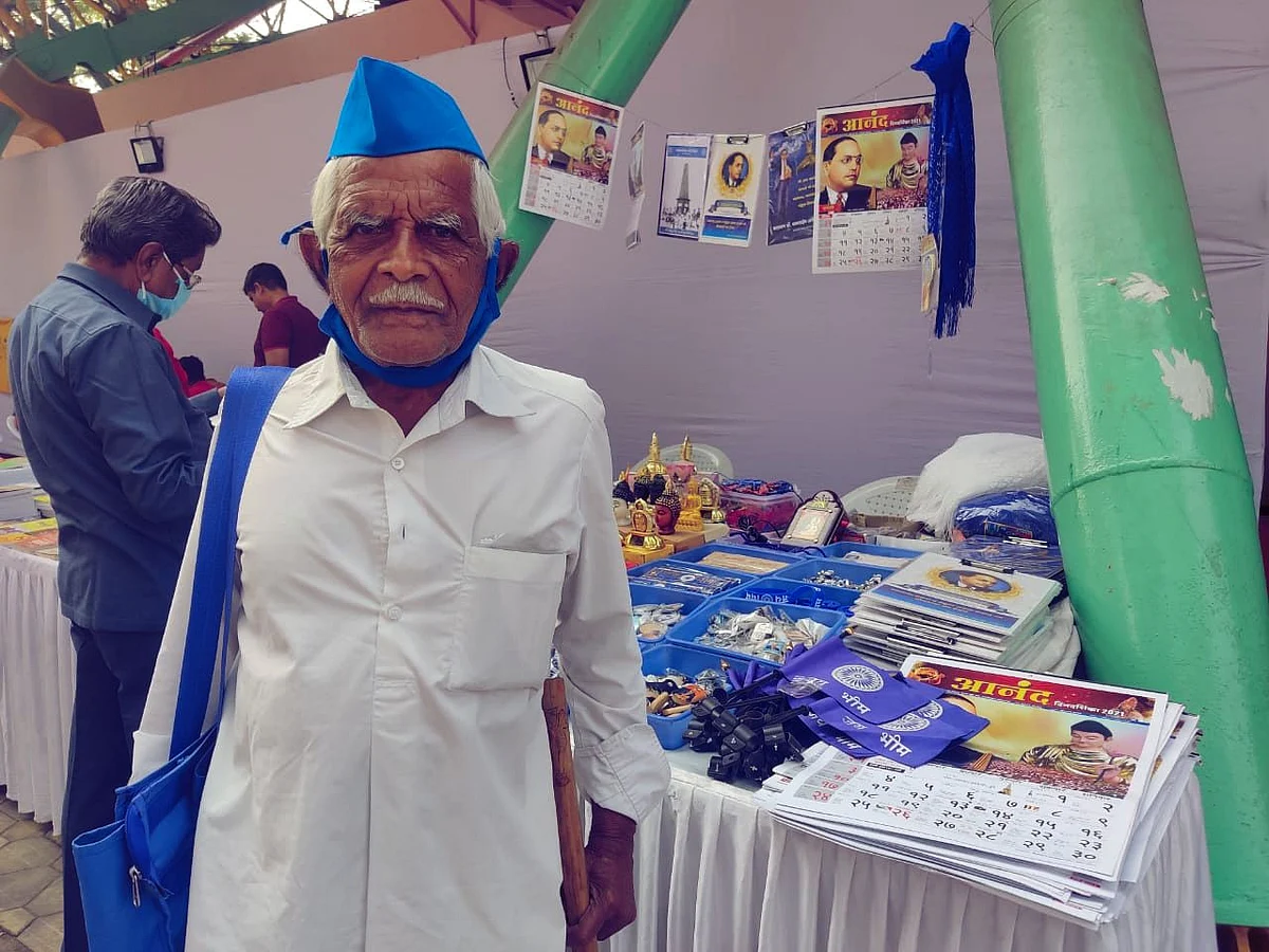 Thackrji Gaikwad, 80-year-old farmer, standing at a book stall at the Elgar Parishad event in Pune