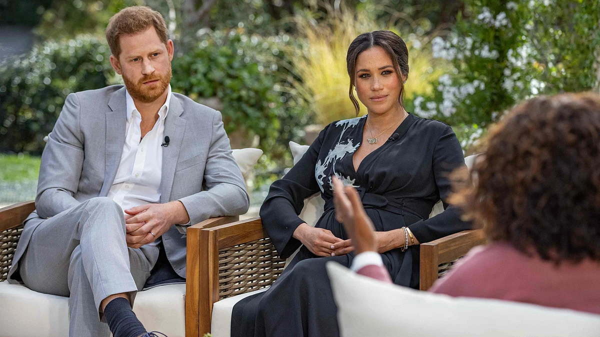 This undated image released March 7, 2021 courtesy of Harpo Productions shows Britain's Prince Harry (L) and his wife Meghan (C), Duchess of Sussex, in a conversation with US television host Oprah Winfrey.