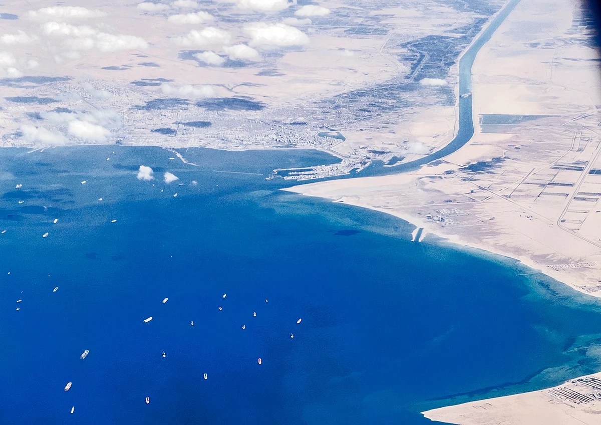 An aerial view taken on March 27, 2021 from the porthole of a commercial plane shows stranded ships waiting in queue in the Gulf of Suez to cross the Suez Canal at its southern entrance near the Red Sea port city of Suez.