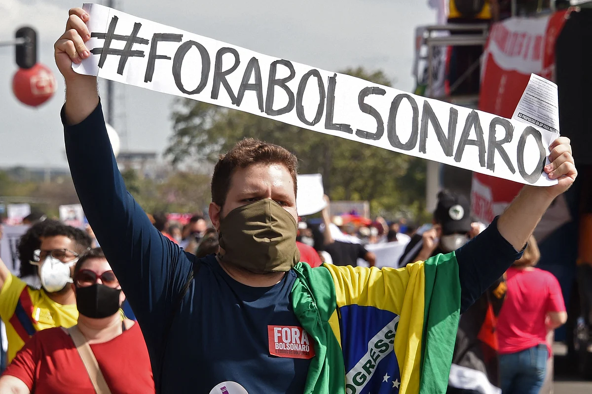 A demonstrator holds a banner reading Bolsonaro out, referring to Brazilian President Jair Bolsonaro during a protest against his handling of the COVID-19 pandemic, in Brasilia, on May 29, 2021.