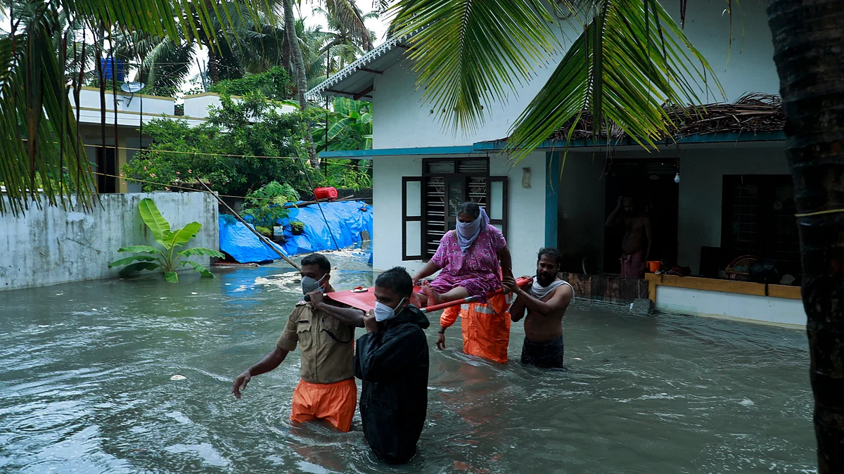 Police and rescue personnel evacuate local residents from a flooded house in a coastal area after heavy rains under the influence of cyclone Tauktae in Kochi