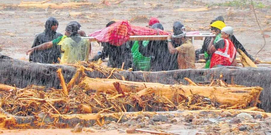 പുത്തുമലയിലെ ദുരന്തത്തിന് ഇരയായ ആളുടെ മൃതദേഹം കണ്ടെടുക്കുന്ന രക്ഷാപ്രവര്ത്തകര് 