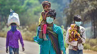 Migrant workers from Madhya Pradesh walk along the Mumbai-Ahmedabad highway, following the coronavirus lockdown, in Palghar, Monday, 30 March.