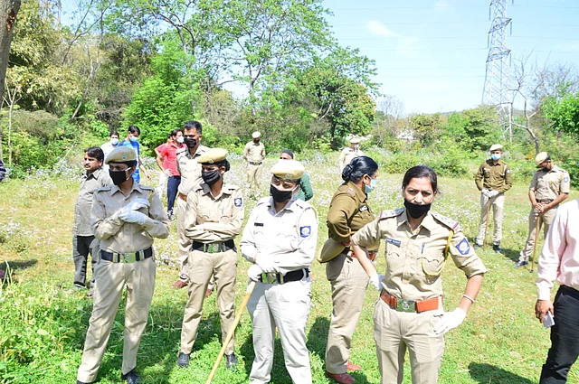 The police looking over at Dilshad’s home, while other officials conduct their investigation.