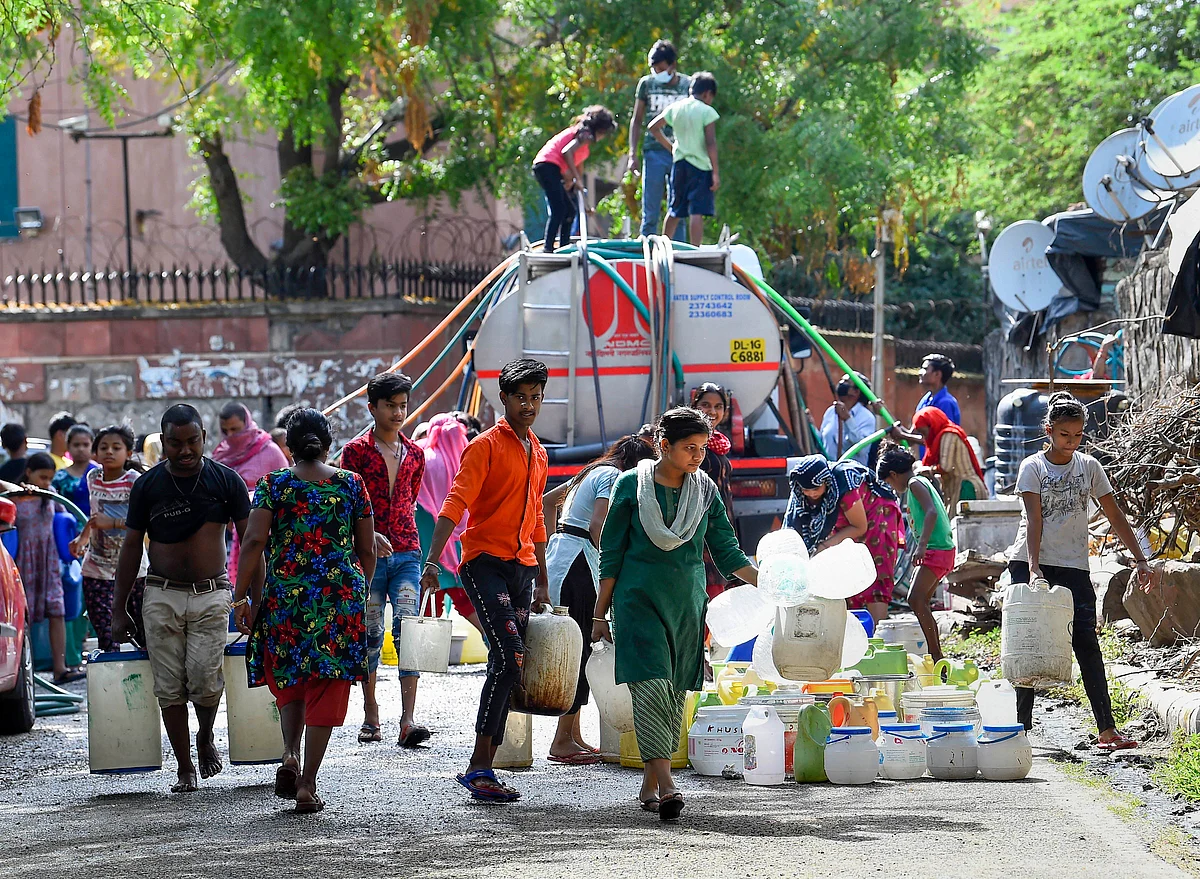 People collect drinking water from a tanker at Vivekanand Camp, Chanakyapuri without following social-distancing guidelines, during the ongoing COVID-19 lockdown in New Delhi on Friday, 17 April.