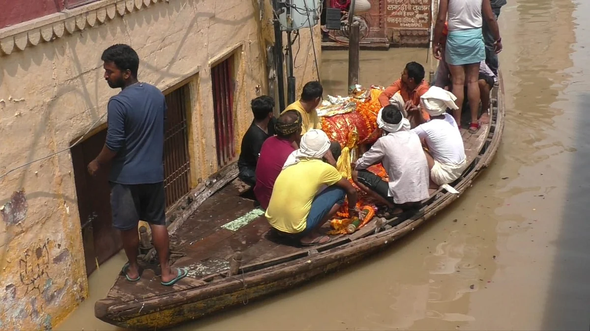 वाराणसी: महाश्मशान मणिकर्णिका घाट डूबा, नाव से शव ले जा रहे परिजन, ऐसे हो रही अंत्येष्टि