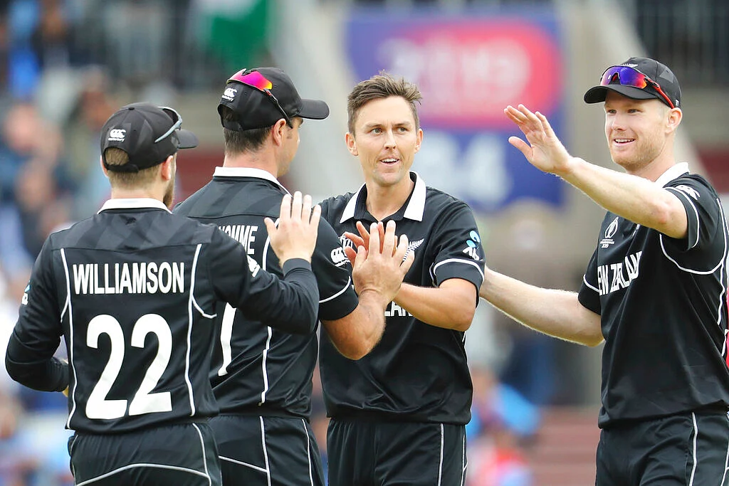 New Zealand's Trent Boult, without cap, celebrates with teammates after dismissing India's Ravindra Jadeja during the Cricket World Cup semifinal match.