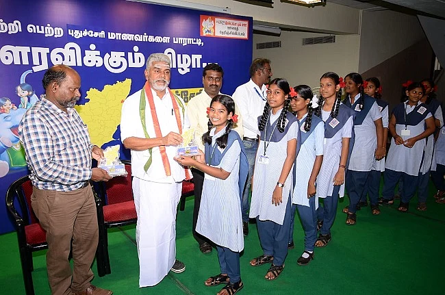 அமைச்சரிடம் பரிசு பெறும் மாணவிகள்