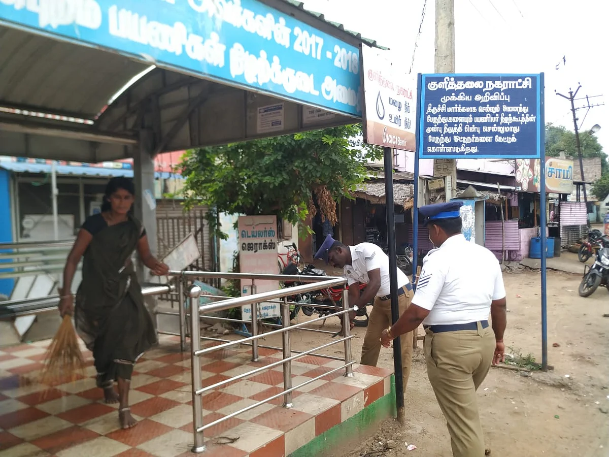 பேருந்து நிறுத்தத்தைச் சுத்தப்படுத்தும் டிராஃபிக் போலீஸ்