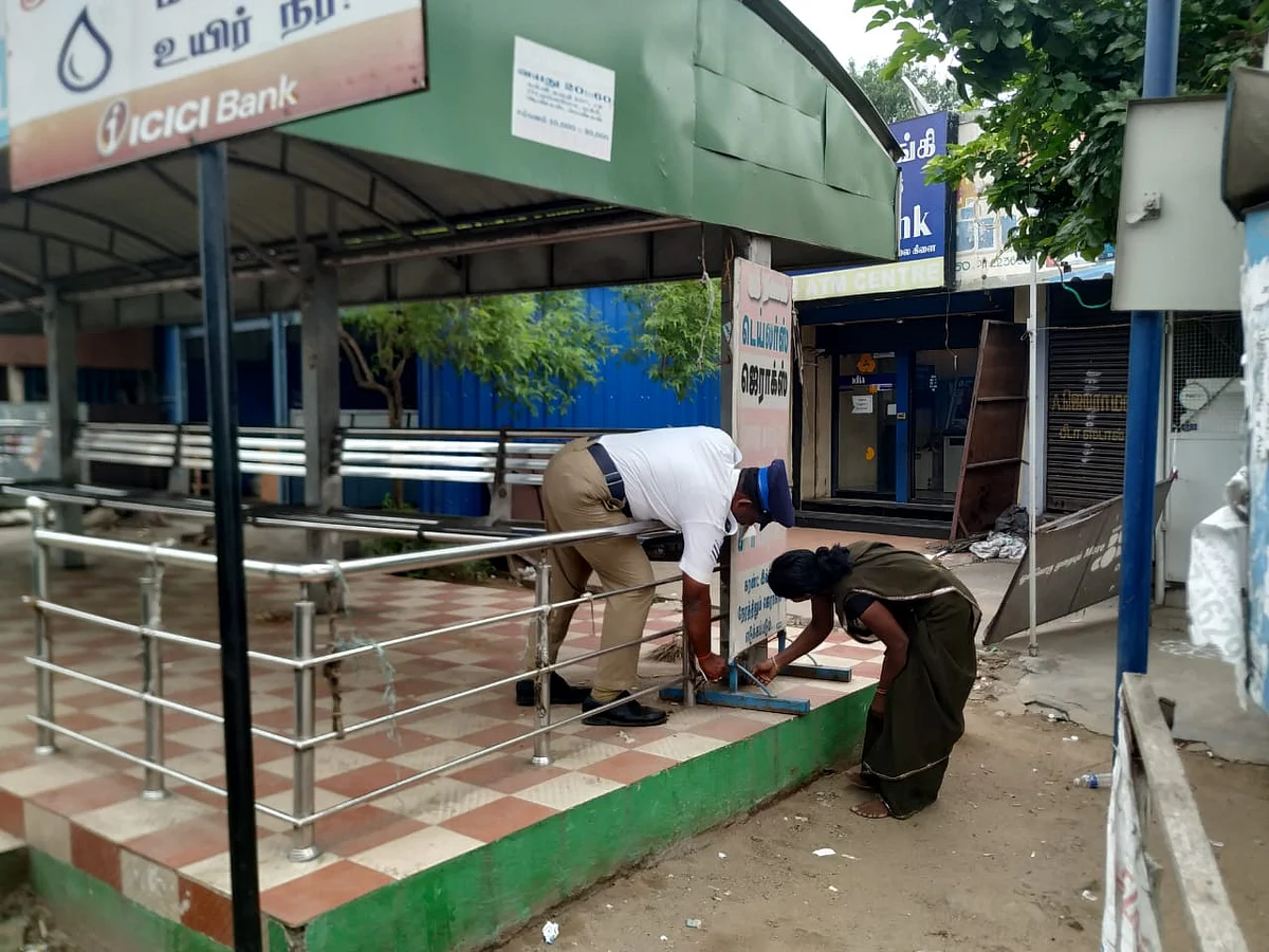 பேருந்து நிறுத்தத்தைச் சுத்தப்படுத்தும் டிராஃபிக் போலீஸ்