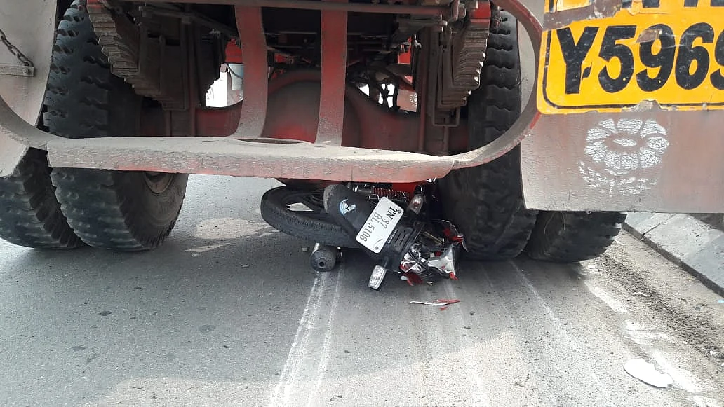 லாரியின் அடியில் கிடக்கும் டூவீலர்