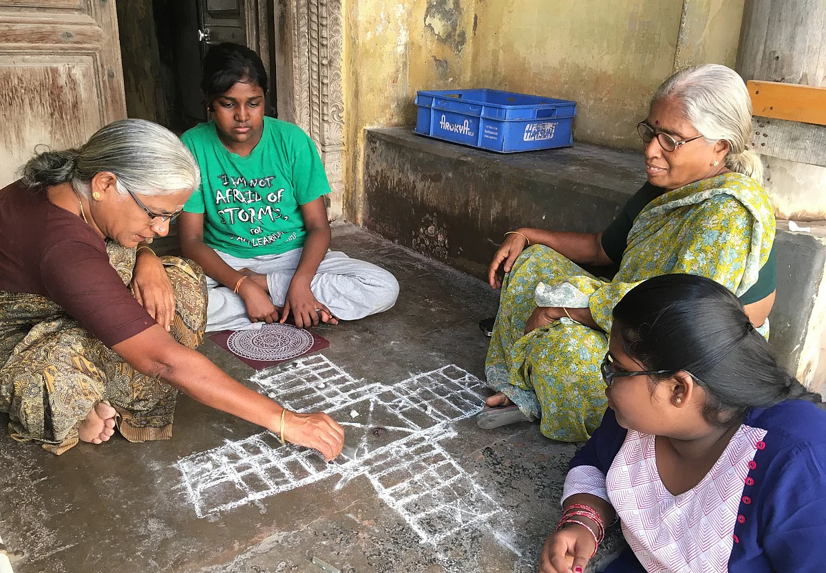 போக்குவரத்து தடை காரணமாக வாகனங்களின் ஒலிப்பான்கள் சப்தம் இல்லாததால் வீட்டு வாசலில் பல்லாங்குழி விளையாடும் பெண்கள்