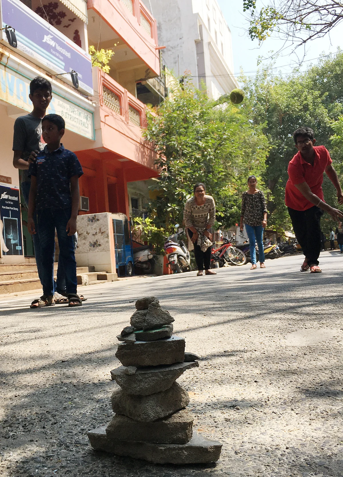 பாரம்பரிய கிராமத்து விளையாட்டுகளை நகர்புற வீதியில் விளையாடும் மாணவர்கள்