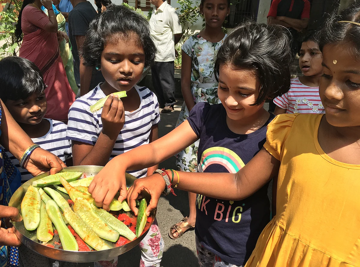 வீதியில் விளையாடும் குழந்தைகளுக்கு உடலுக்கு இதமான வெள்ளரிக்காய், தற்பூசணி வழங்கப்பட்டன