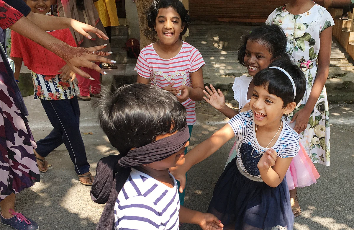 போக்குவரத்து தடை செய்யப்பட்ட வீதியை மைதானமாக நினைத்து மகிழ்ச்சியுடன் கண்களை கட்டி விளையாடும் குழந்தகள்