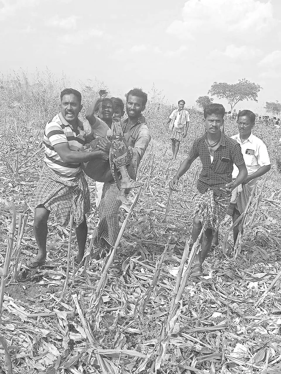 காயம்பட்டவரை தூக்கிச் செல்லும் ஊர்மக்கள்