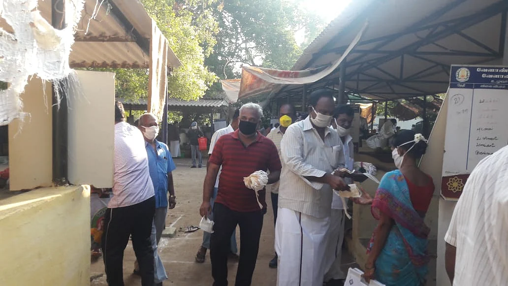பொதுமக்களுக்கு முகக்கவசம் கொடுக்கும் தி.மு.க-வினர்.