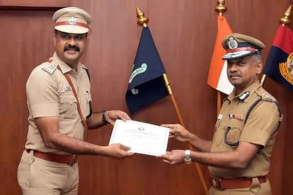 போலீஸ் கமிஷனரிடம் பாராட்டுச் சான்றிதழை பெறும் உதவி கமிஷனர் சுதர்சன்