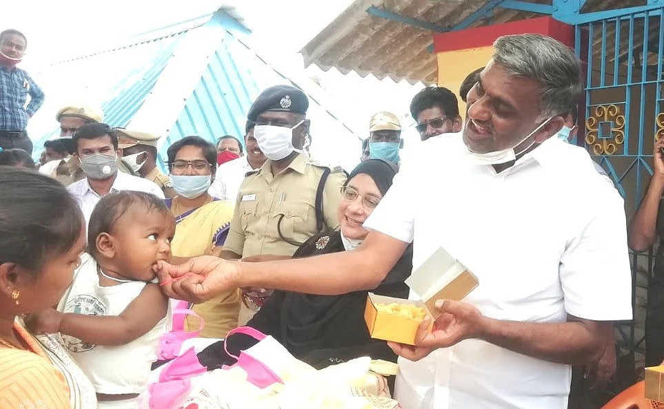 குழந்தைக்கு இனிப்பு ஊட்டும் அமைச்சர் வீரமணி