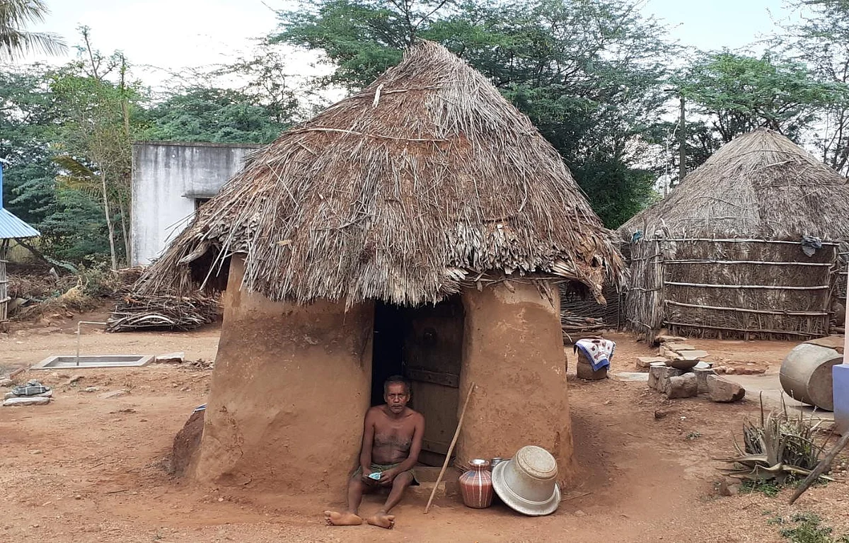 குடிசை வீட்டின் முன்பு மாரியப்பன்