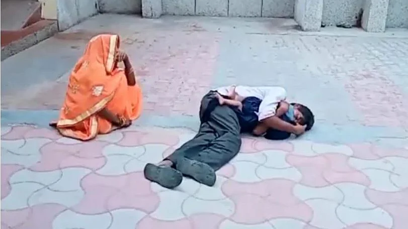 குழந்தையின் உடலைக் கட்டியணைத்தபடி அழும் தந்தை