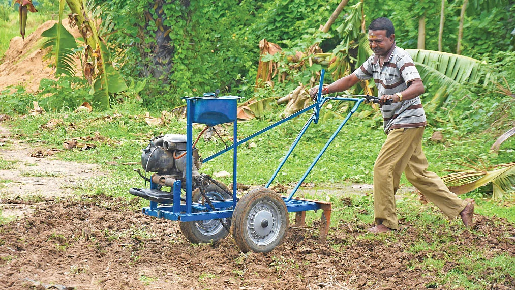 தான் உருவாக்கிய களைவெட்டும் கருவியுடன் நம்பிராஜன்