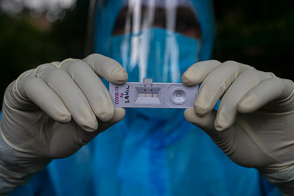 A health worker shows a sample kit of a COVID-19 positive test during a door to door test drive in Gauhati, India