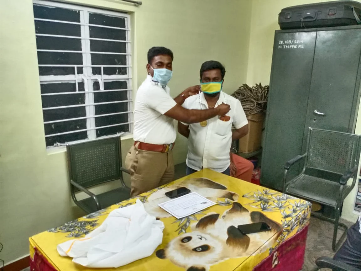 இளைஞருக்கு பதக்கம் அணிவிக்கும் கார்த்திகேயன்