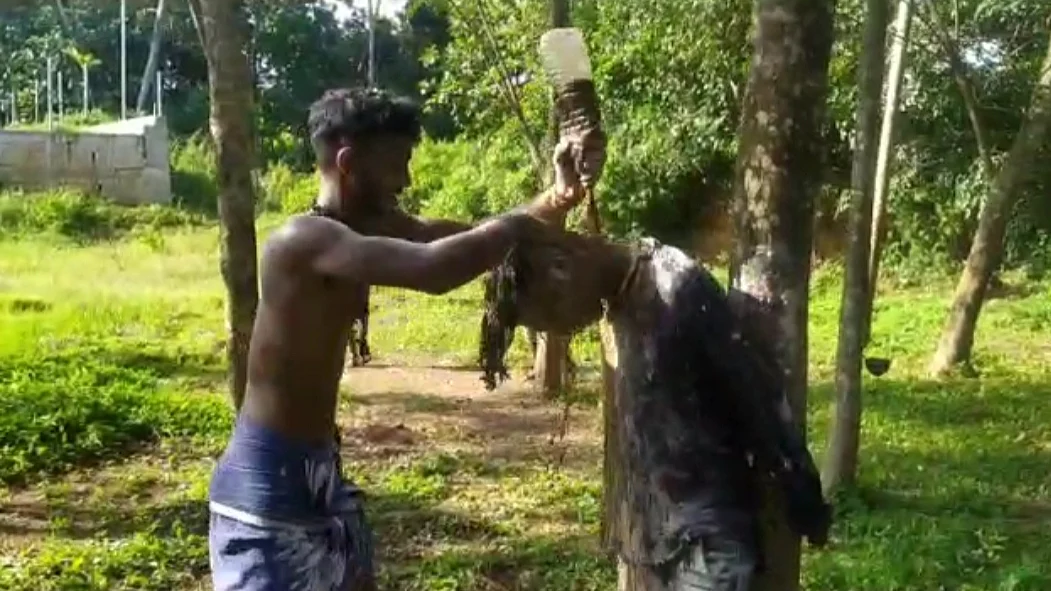 வாலிபரைக் கட்டிவைத்து சாணித் தண்ணீரை ஊற்றும் நண்பர்கள்